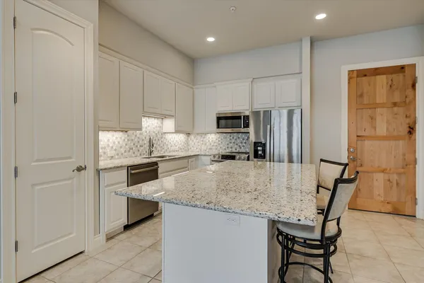 a kitchen with kitchen island a counter top space appliances and cabinets