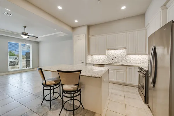 a kitchen with granite countertop a sink stove and refrigerator