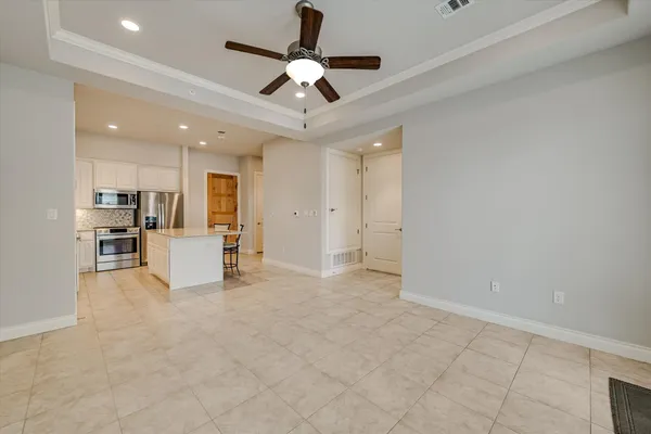 an empty room with windows and ceiling fan