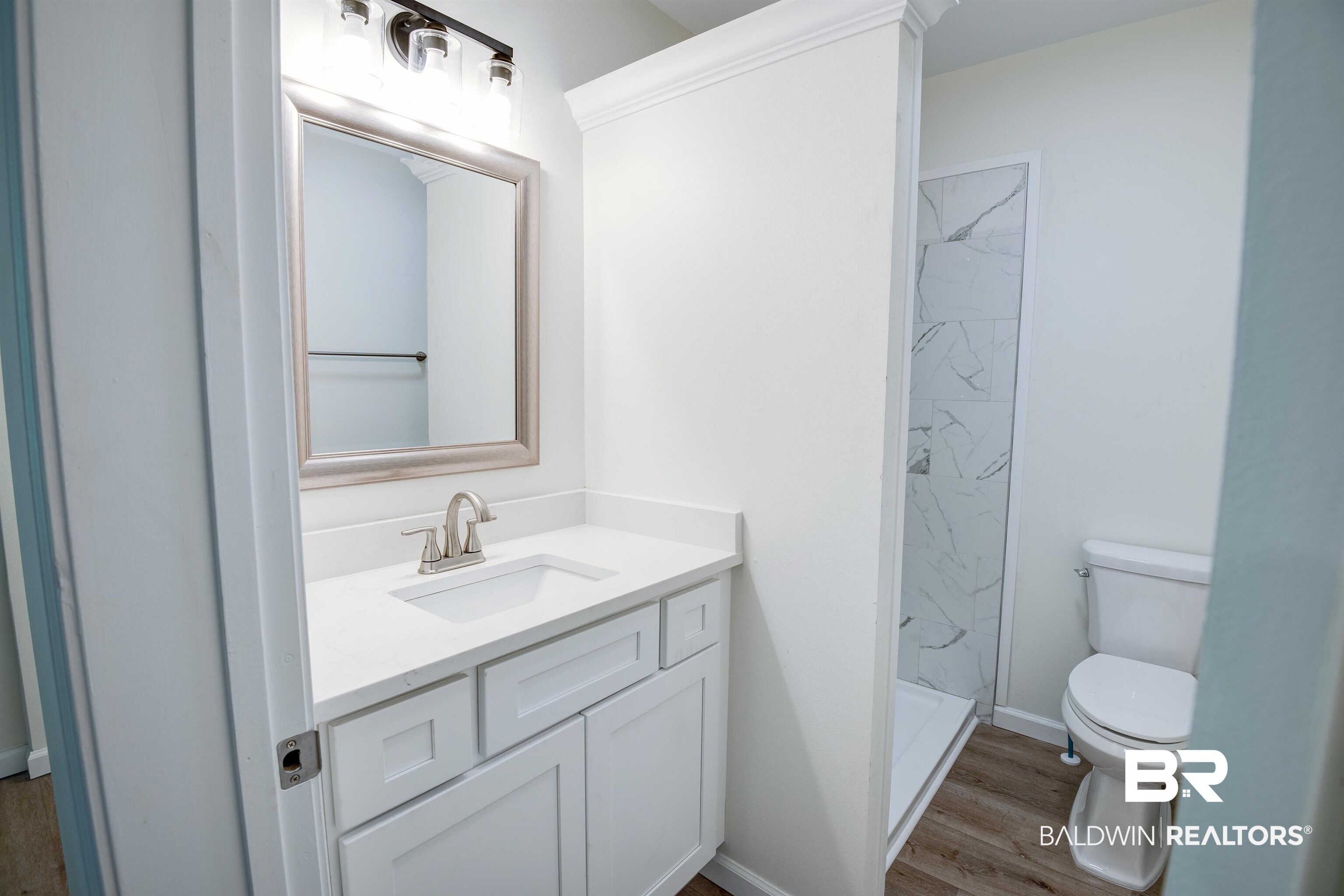 510 East Myrtle Avenue Foley, AL 36535 - Photo 16 of 22 Full bath featuring vanity, a marble finish shower, and wood finished floors