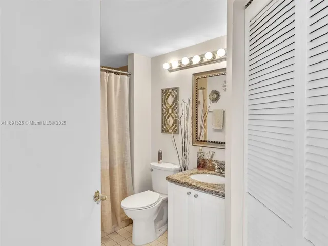 a bathroom with a granite countertop sink toilet a mirror and a shower