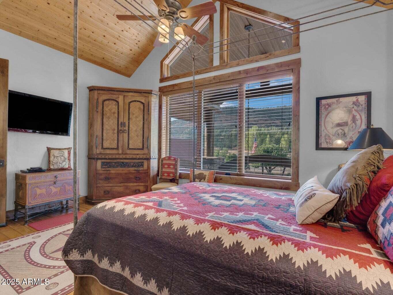 9361 Juniper Road Strawberry, AZ 85544 - Photo 43 of 104 a spacious bedroom with a bed and a flat screen tv