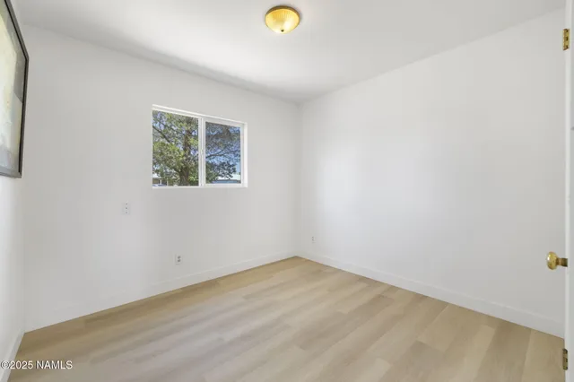 a view of a room with wooden floor and a window