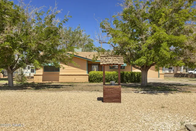 a front view of a house with a yard and tree s