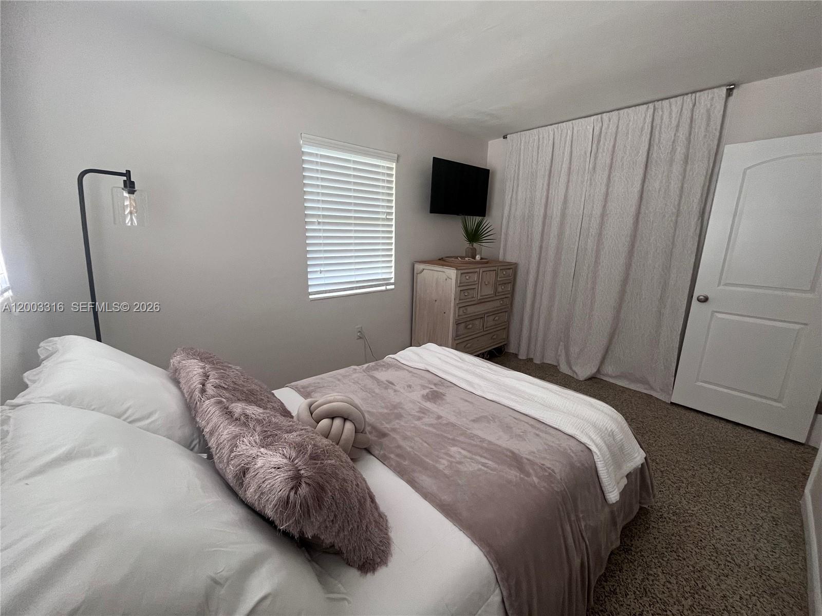 9840 Southwest 165th Terrace Miami, FL 33157 - Photo 11 of 13 a bedroom with a bed and a window