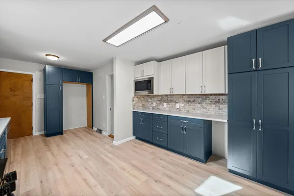 a spacious bathroom with a granite countertop sink mirror and cabinets
