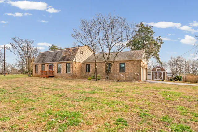 a view of a large white house with a yard covered with snow