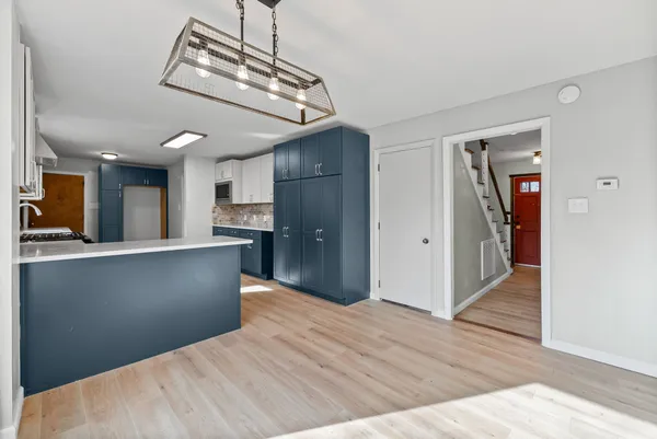 a view of a kitchen with wooden floor and a hallway