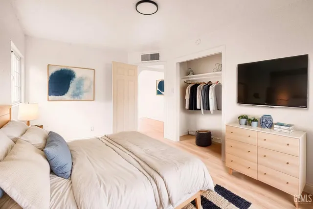 a bedroom with a large bed and a flat screen tv