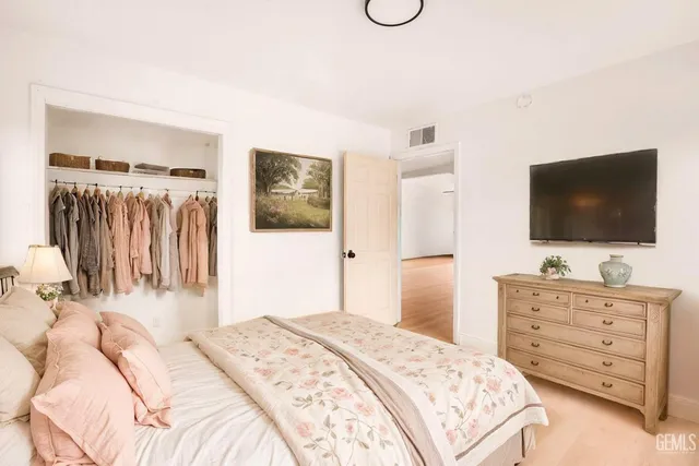 a bedroom with a bed and a flat screen tv in it