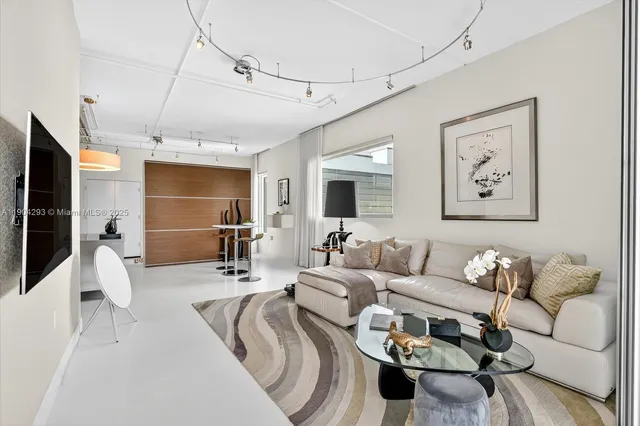 a living room with furniture a flat screen tv and kitchen view