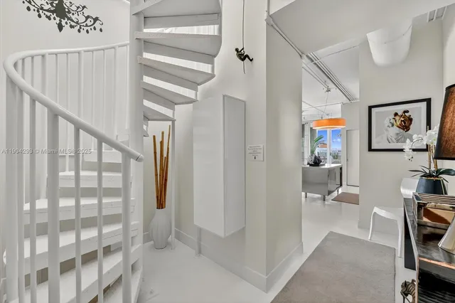 a view of a hallway with workspace and entryway with furniture