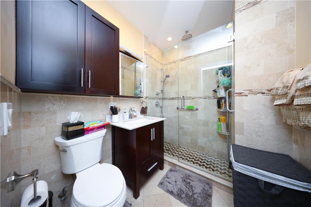 8785 14th Avenue, Unit 1B Brooklyn, NY 11228 - Photo 12 of 29 a bathroom with a sink a toilet and shower