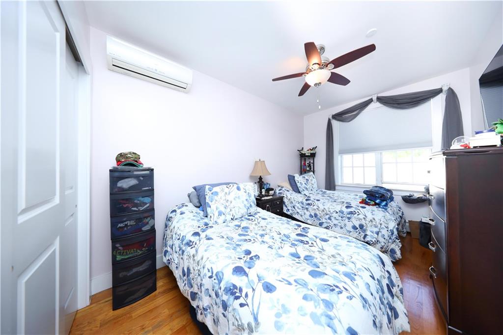 8785 14th Avenue, Unit 1B Brooklyn, NY 11228 - Photo 13 of 29 a bedroom with a bed and a chandelier