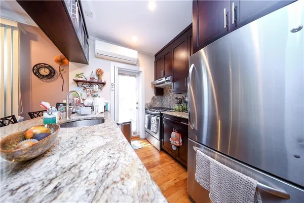 a kitchen with stainless steel appliances granite countertop a refrigerator a stove and a sink