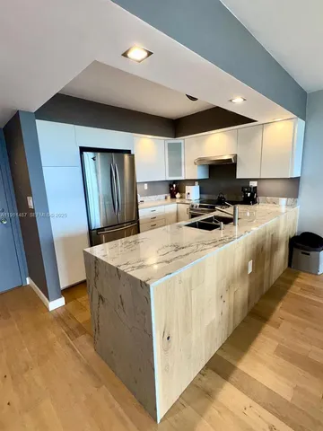 a kitchen with stainless steel appliances granite countertop a sink a stove and a refrigerator