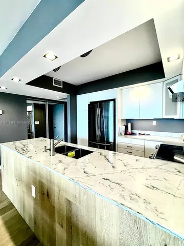 a large kitchen with kitchen island sink stainless steel appliances and cabinets