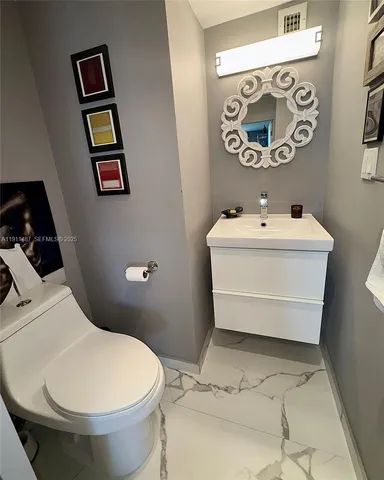 a bathroom with a toilet sink and mirror