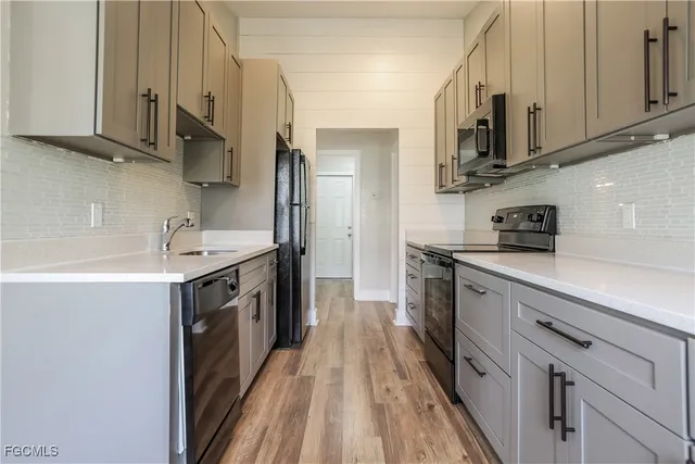 a kitchen with stainless steel appliances granite countertop a sink a stove and a refrigerator