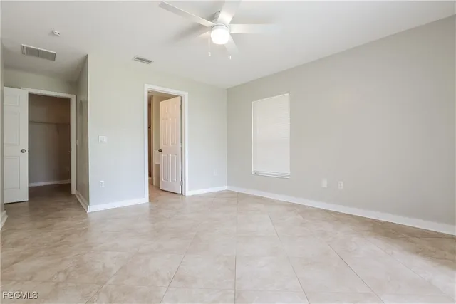 an empty room with closet and a chandelier fan