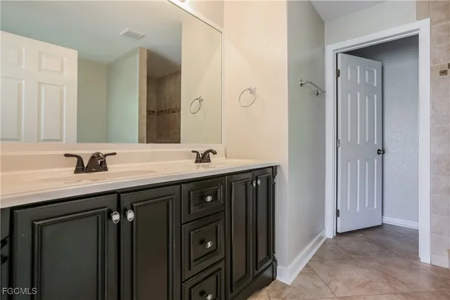 a bathroom with double vanity sinks and a mirror