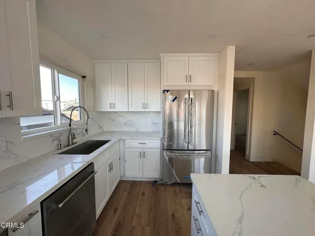 a kitchen with a sink a refrigerator and cabinets