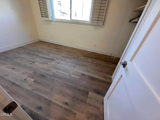 a view of a room with wooden floor and window
