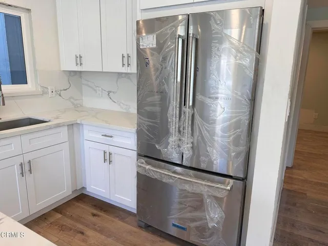 a kitchen with stainless steel appliances white cabinets and a granite counter