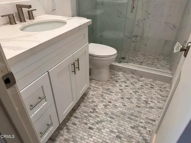 a bathroom with a sink a toilet and shower