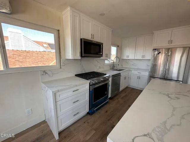 a kitchen with stainless steel appliances a stove a sink and a microwave