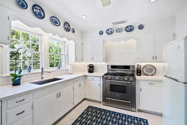 a kitchen with a stove a sink and a window