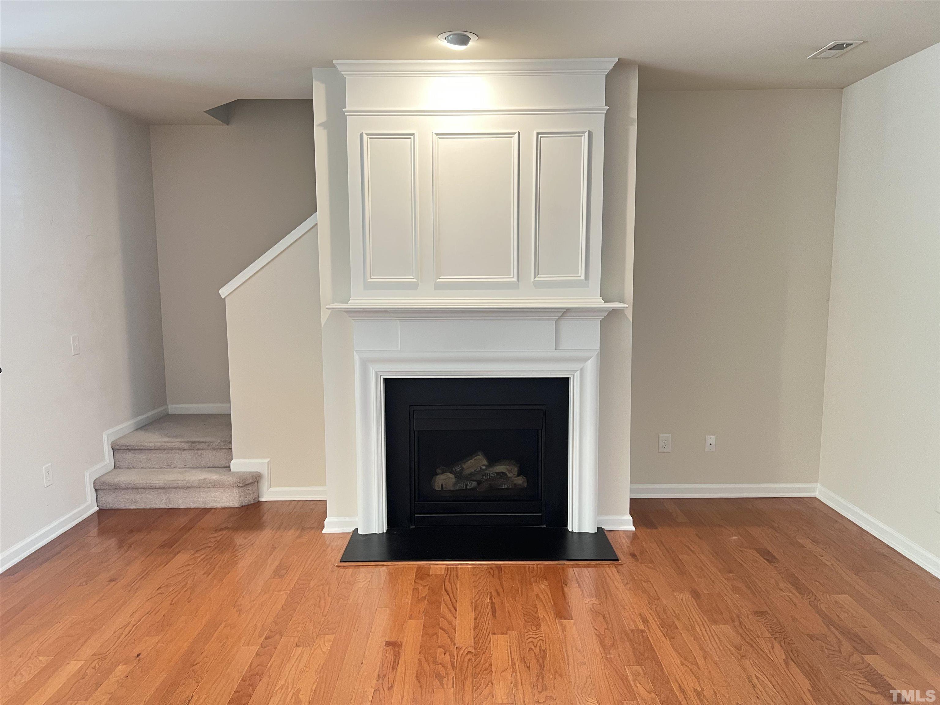 7110 Racine Way Raleigh, NC 27615 - Photo 3 of 19 a view of an empty room with wooden floor fireplace and a window