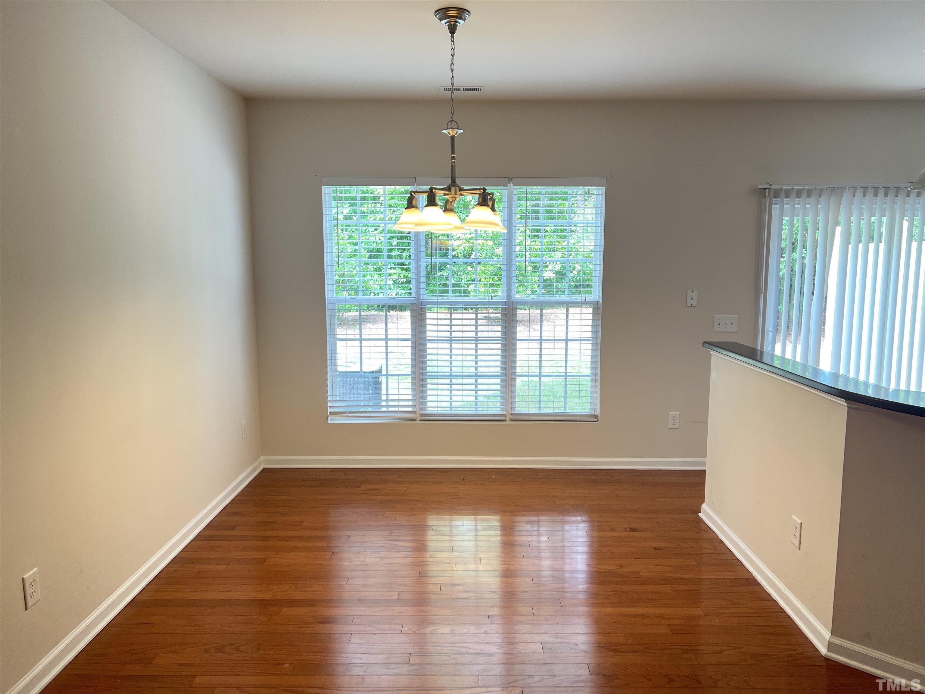 7110 Racine Way Raleigh, NC 27615 - Photo 5 of 19 a view of an empty room with wooden floor and a window