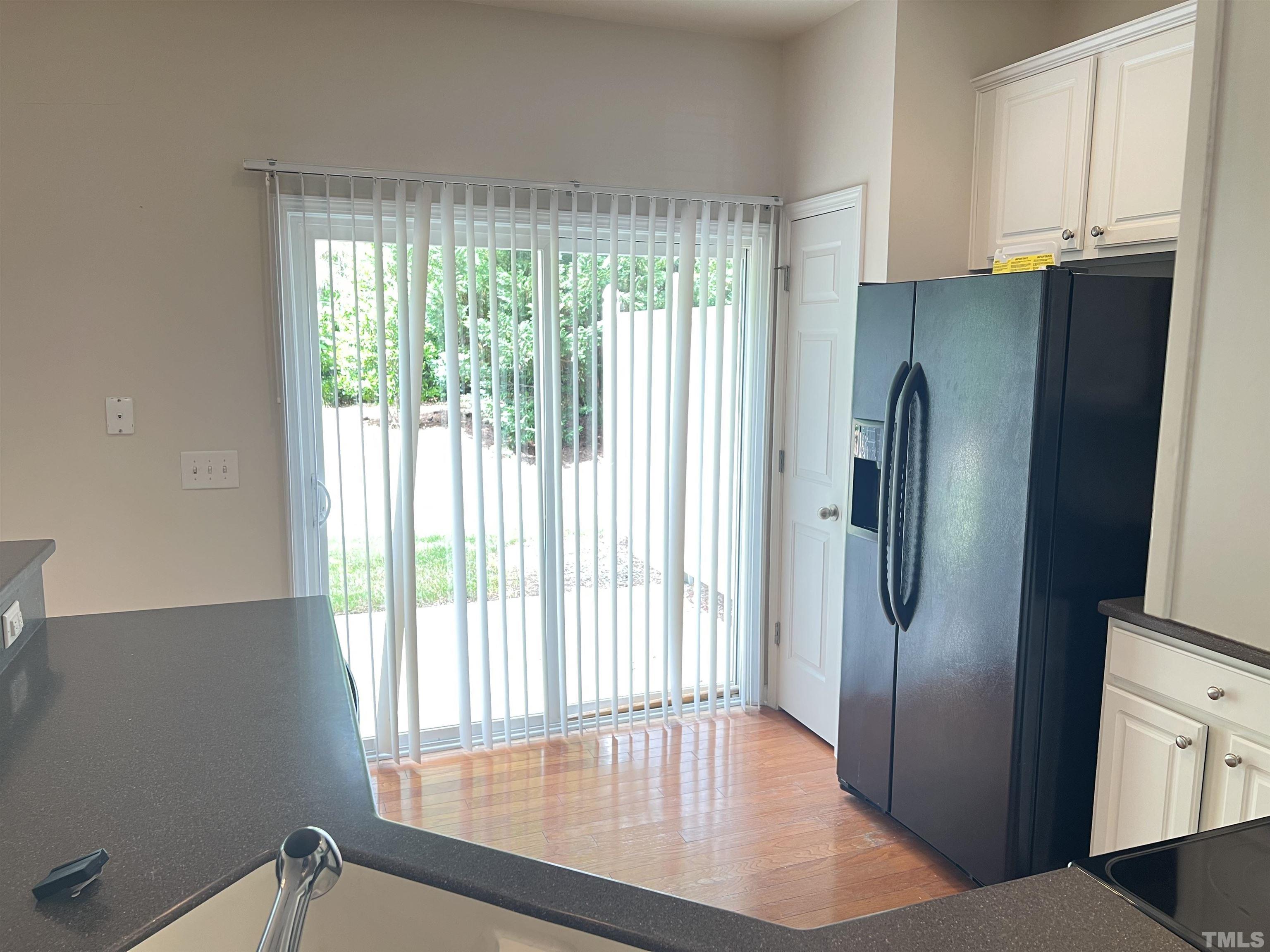 7110 Racine Way Raleigh, NC 27615 - Photo 8 of 19 a view of a refrigerator a window and wooden floor