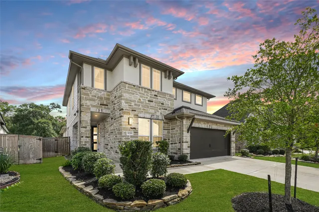 a front view of a house with a yard and green space