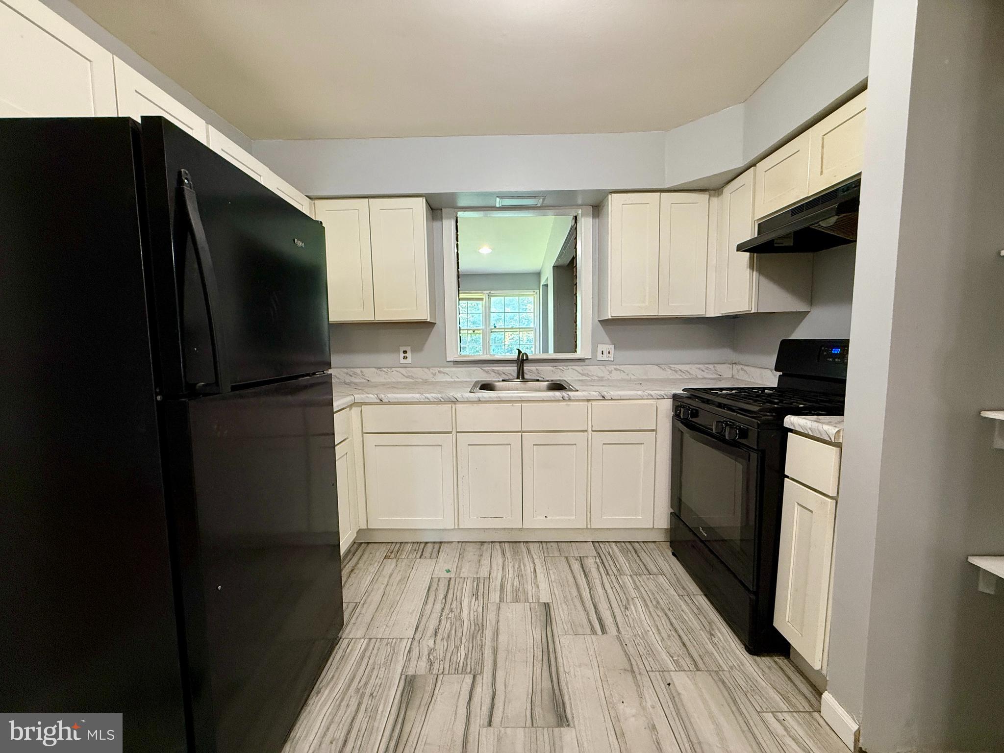 701 Harrison Street Riverside, NJ 08075 - Photo 11 of 26 a kitchen with a refrigerator a sink and dishwasher with wooden floor