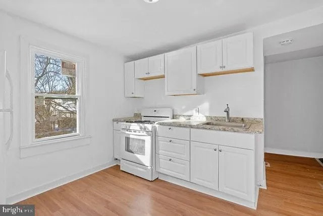 a kitchen with granite countertop white cabinets and white appliances