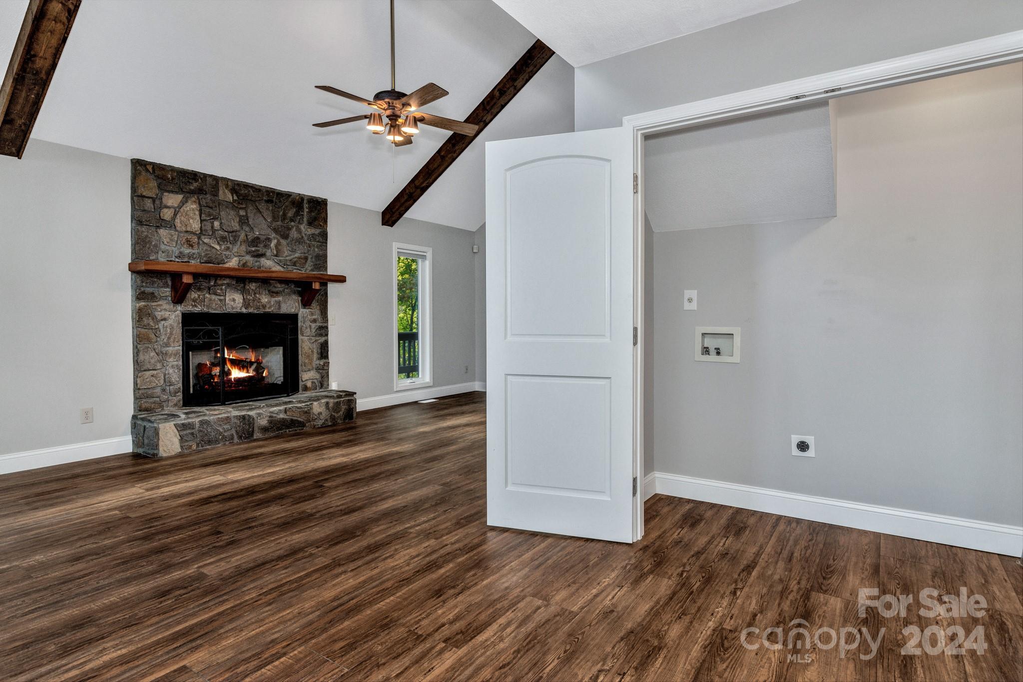 122 Kings Ridge Road Maggie Valley, NC 28751 - Photo 23 of 47 a view of an empty room with wooden floor fireplace and a window