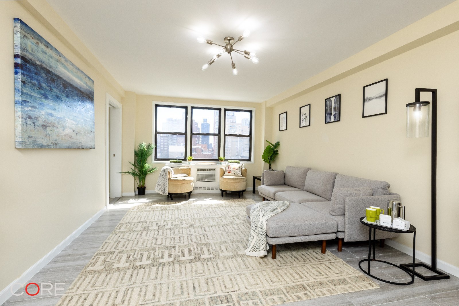 241 East 76th Street, Unit 9I Manhattan, NY 10021 - Photo 4 of 13 a living room with furniture and a chandelier