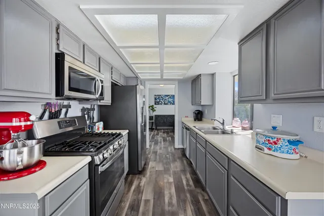 a kitchen with kitchen island granite countertop lots of counter top space a sink stainless steel appliances and cabinets