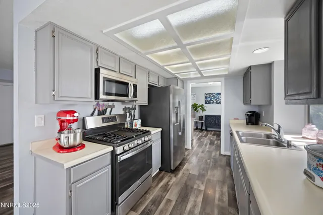 a kitchen that has a lot of cabinets a stove and a wooden floor