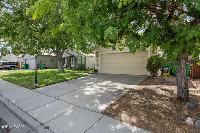 a view of a house with a yard and large tree