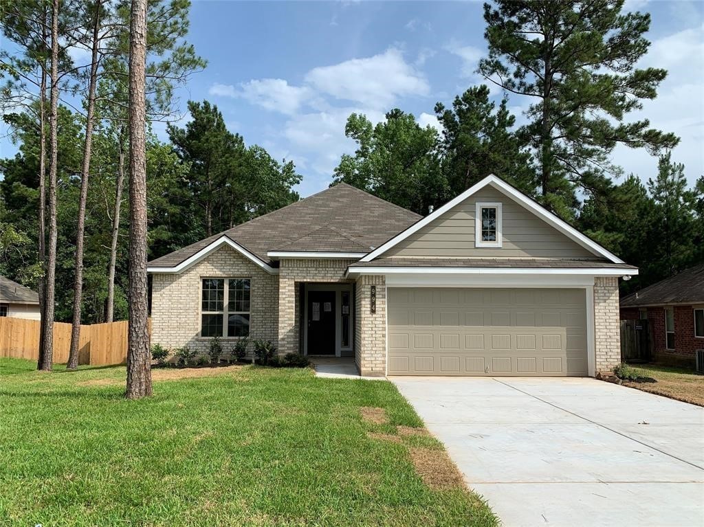 994 Arbor Crossing Conroe, TX 77303 - Photo 1 of 9 a front view of a house with a garden and trees