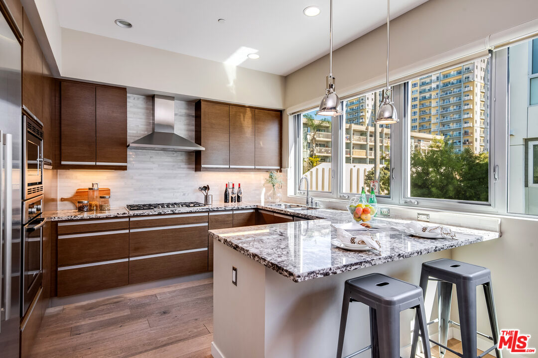 310 Washington Boulevard, Unit 401 Marina del Rey, CA 90292 - Photo 13 of 32 a kitchen with stainless steel appliances granite countertop a stove a sink and a refrigerator