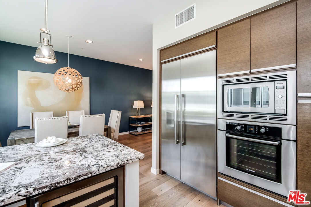 310 Washington Boulevard, Unit 401 Marina del Rey, CA 90292 - Photo 14 of 32 a kitchen with a refrigerator a stove and a wooden floor