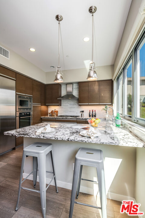 310 Washington Boulevard, Unit 401 Marina del Rey, CA 90292 - Photo 15 of 32 a kitchen with stainless steel appliances granite countertop a sink a stove and a wooden floors