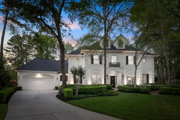 a front view of a house with a yard and trees