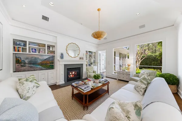 a living room with furniture fireplace and a large window