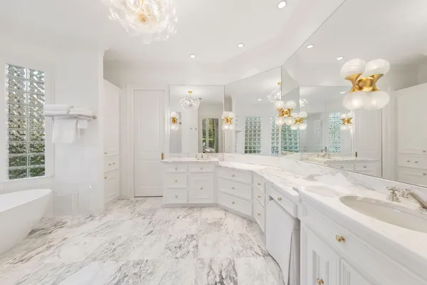 a spacious bathroom with a granite countertop sink a large mirror and a shower