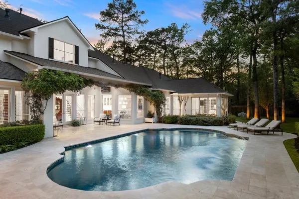 a view of a house with pool and chairs